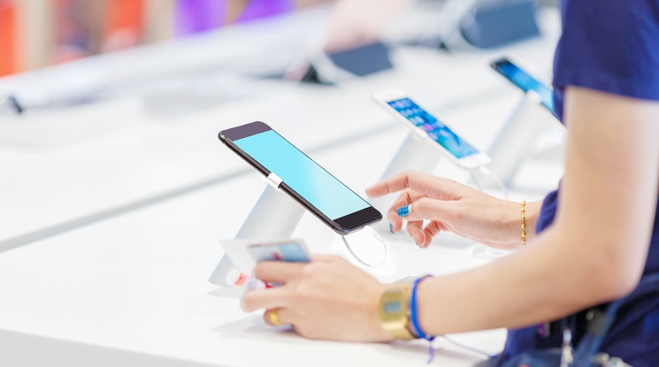 Woman,choosing,a,new,mobile,phone,in,a,shop,focus