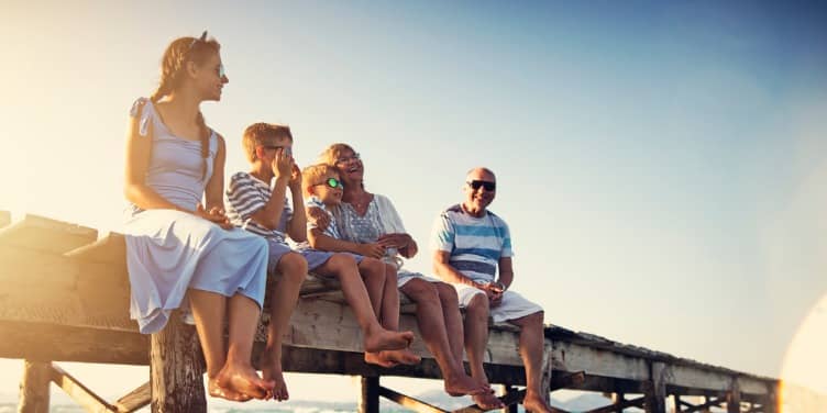 Family sitting on pier by the sea