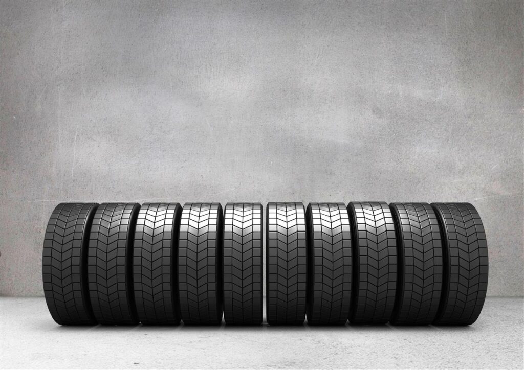 Digital Composite Image Of Tyres Arranged In A Row Against Concrete Wall